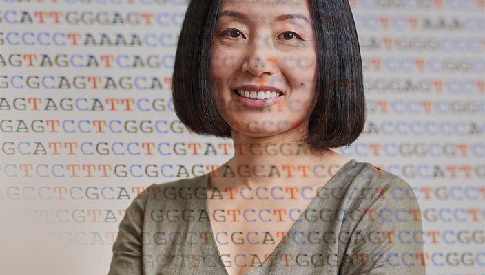 Una mujer sonriendo con las letras del código del ADN superpuestas en la imagen.