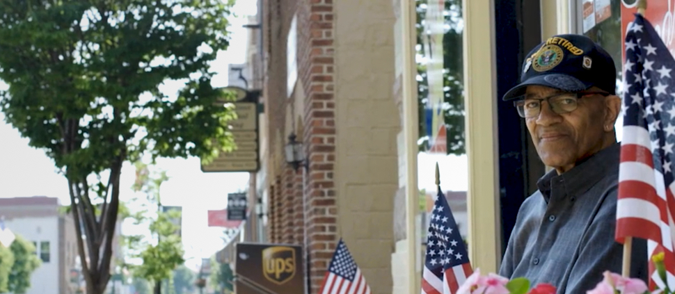 Image of a veteran near US flags