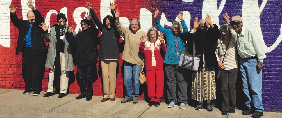 Image of ethnically diverse older adults against mural