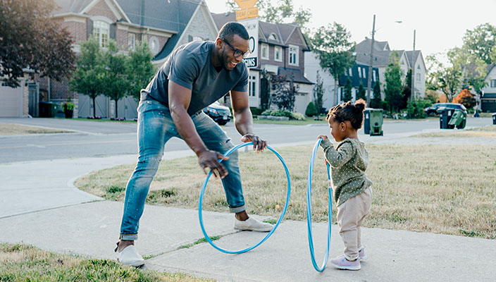 A father and child playing with toy hoops.