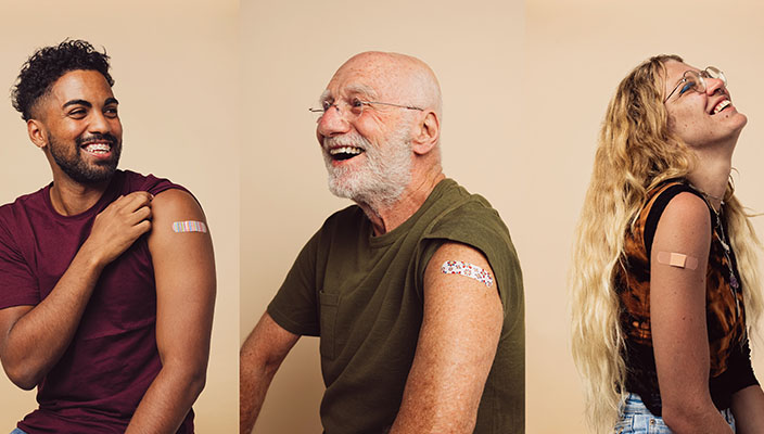 Tres personas muestran vendas adhesivas en los brazos, sobre el lugar en el que fueron vacunadas.