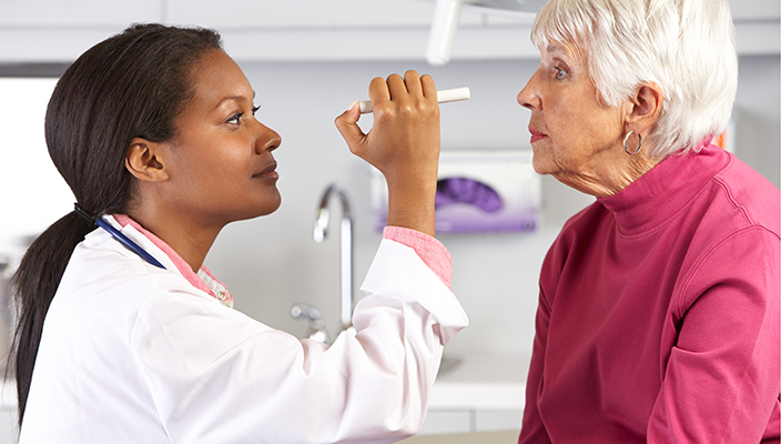 A health care provider examining a patient’s eyes.