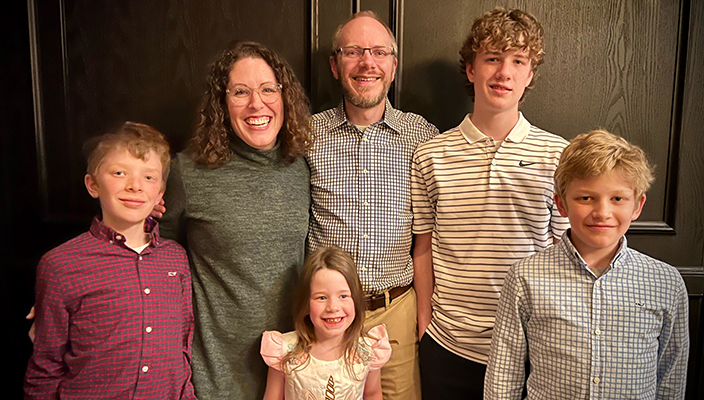 Josh y Carolyn Denny sonriendo con sus cuatro hijos