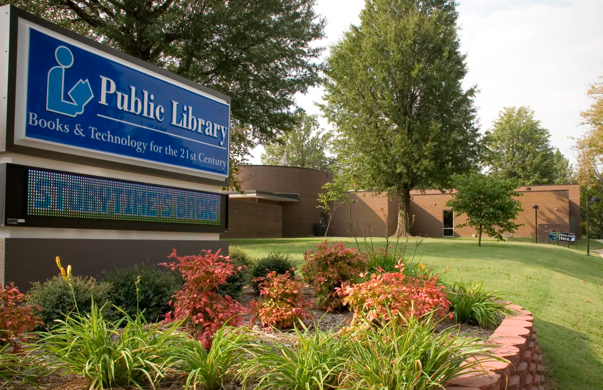 Front walkway with a blue sign that reads "Craighead County Jonesboro Public Library"