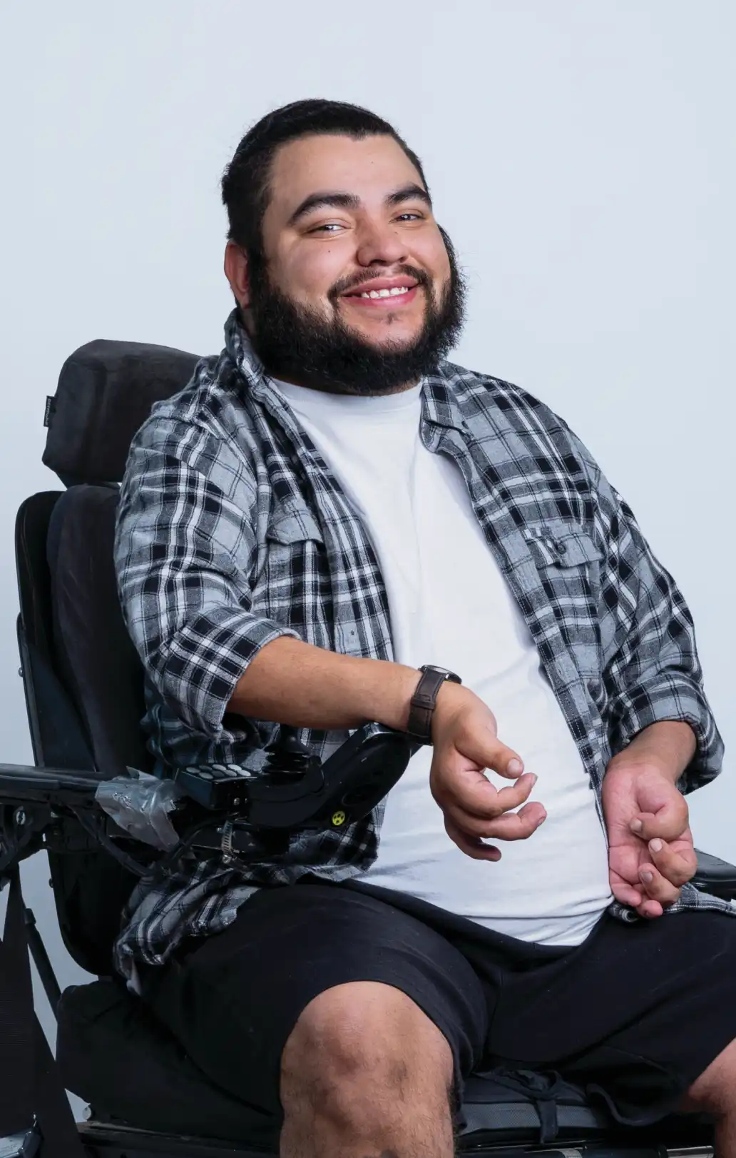 Young man in a motorized wheelchair with a beard and flannel shirt